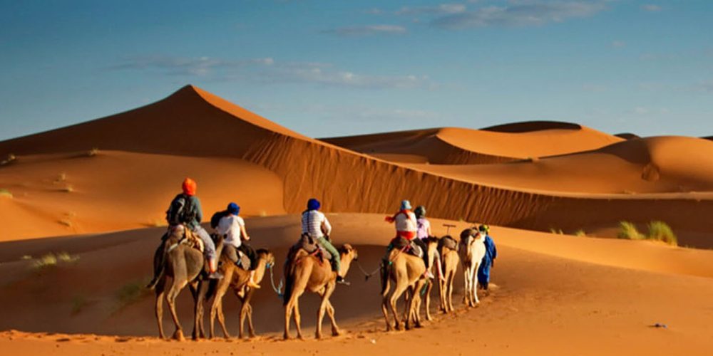 people-riding-camels-in-Dubai-desert
